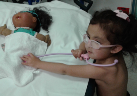Nina takes care of a doll at the hospital