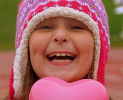 Young girl in pink hat smiling