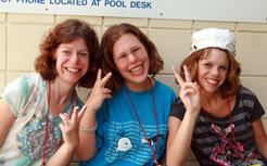 three people smiling and holding up peace signs